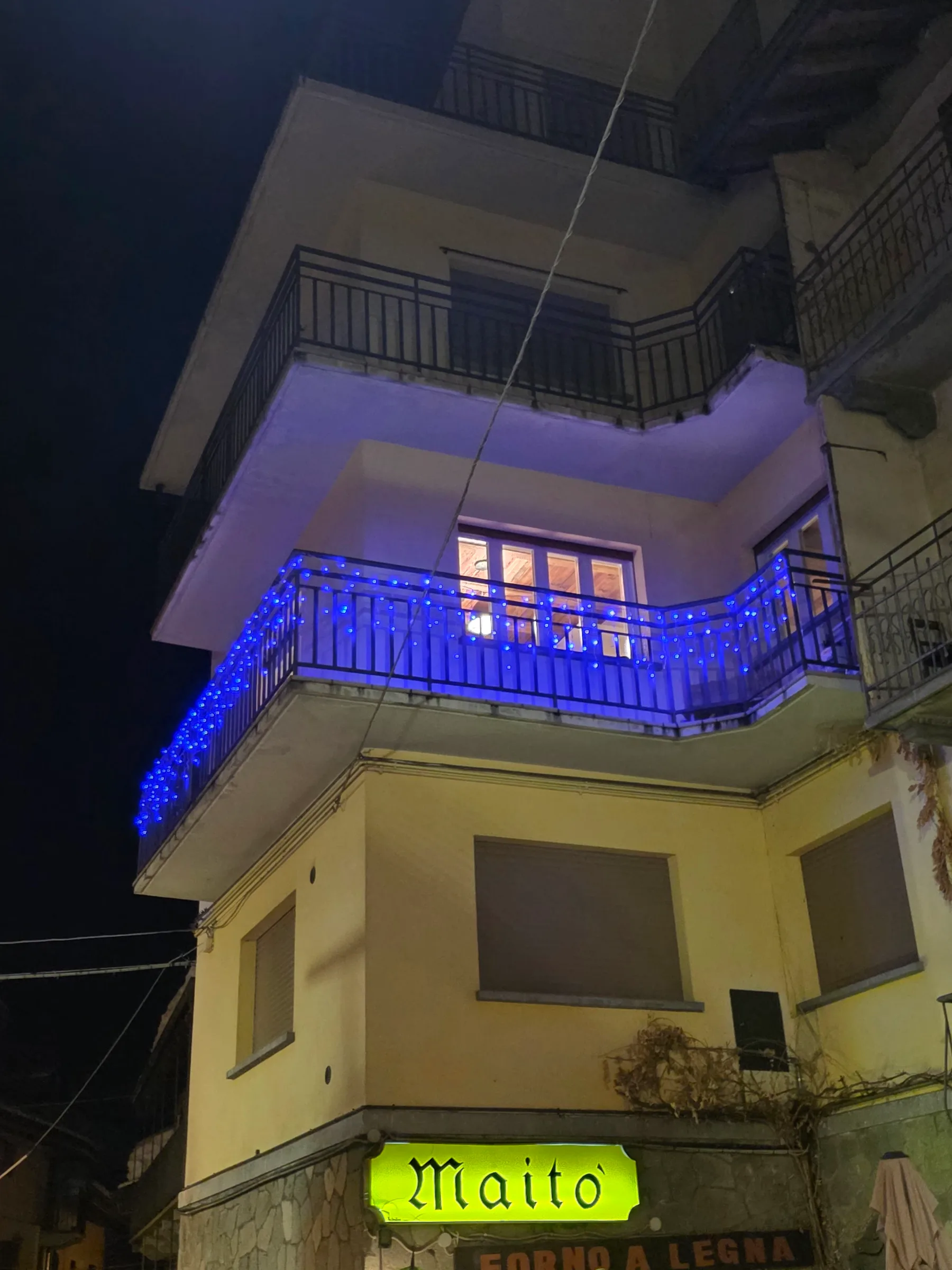 Illuminated second-floor balcony of Bijou Limone at night